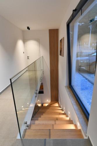 a glass staircase in a house with a fish tank at Villa Marmonte, Luksuzna vila s bazenom i pogledom na more in Medveja