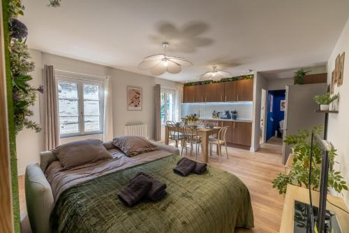 une chambre avec un lit et une salle à manger dans l'établissement L'Escapade Végétale - Centre Ville, à Saumur