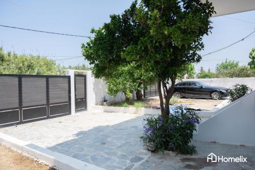 a car parked next to a garage with a tree at Fivi in Áyios Nikólaos