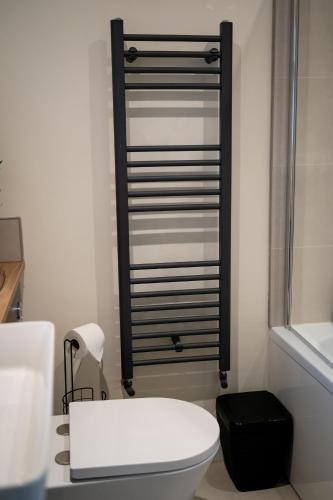 a bathroom with a white toilet and a black towel rack at Two Bed House in Castle Donington in Castle Donington