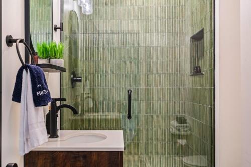 a bathroom with a sink and a glass shower at The Rickhouse - Elegance & Fun Wrapped In One! in Louisville