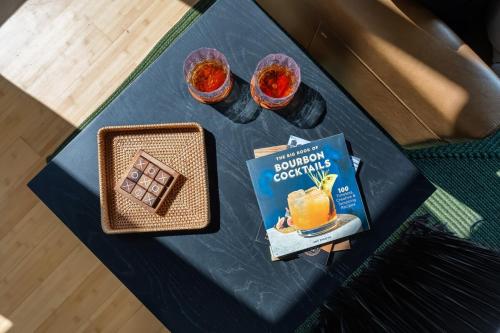 a table with a book and two glasses of orange juice at The Rickhouse - Elegance & Fun Wrapped In One! in Louisville
