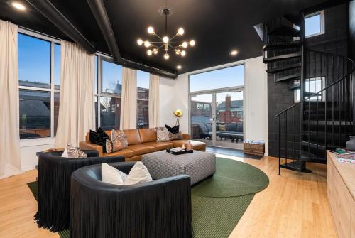 a living room with a couch and a chandelier at The Rickhouse - Elegance & Fun Wrapped In One! in Louisville