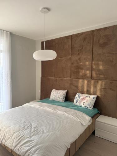 a bedroom with a large bed with a wooden headboard at Sea Apartment in Lezhë