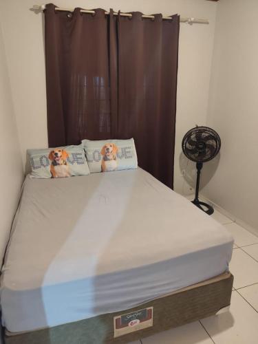 a bedroom with a bed with two dogs on the pillows at Casa perto da Uopecan in Cascavel