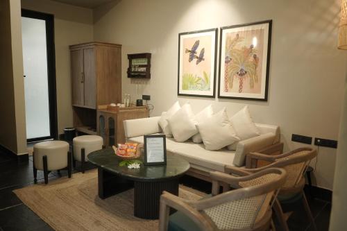a living room with a couch and a table at The Bali House in Bhopal