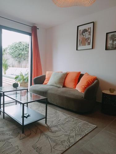 a living room with a couch and a glass table at maison jardin tram,mer 15mn voiture in Saint-Jean-de-Védas