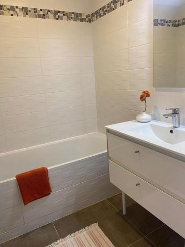 une salle de bain avec un lavabo et une baignoire et un lavabo dans l'établissement maison jardin tram,mer 15mn voiture, à Saint-Jean-de-Védas