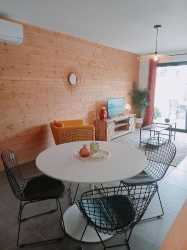 un salon avec une table et des chaises blanches dans l'établissement maison jardin tram,mer 15mn voiture, à Saint-Jean-de-Védas