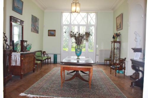 a living room with a table with a vase on it at Château de Miguillaume 