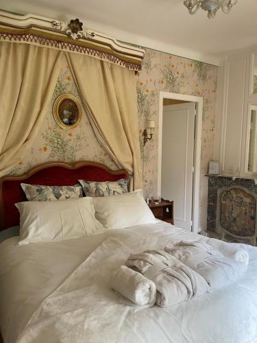 a bedroom with a white bed with a canopy at Château de Miguillaume 