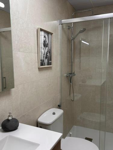 a bathroom with a shower and a toilet and a sink at Apartamento Tavernes Playa in Tavernes de Valldigna