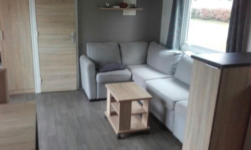 un salon avec un canapé et une table dans l'établissement Mobilhome tout confort, à Pont-Aven
