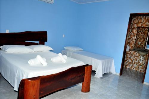 a bedroom with a bed and a blue wall at Pousada Encanto dos Anjos in Pirenópolis