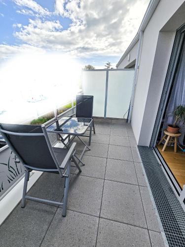 un balcon avec des chaises et une table sur un immeuble dans l'établissement La Parenthèse Sablaise, à Les Sables-dʼOlonne