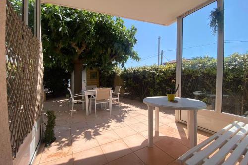un patio avec une table, des chaises et une fenêtre dans l'établissement a garden on the port, à Frontignan