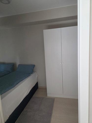 a bedroom with a bed and a white cabinet at Two bedrooms Luxury apartment with free parking in Lorenskog