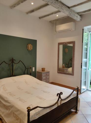 une chambre avec un grand lit et un miroir dans l'établissement andibru, à Antibes