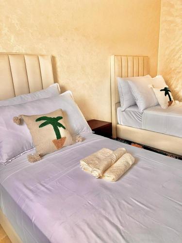 a bedroom with two beds and a cactus pillow at Marakech home in Marrakesh