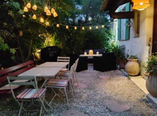 d'une terrasse avec une table, des chaises et des lumières. dans l'établissement andibru, à Antibes