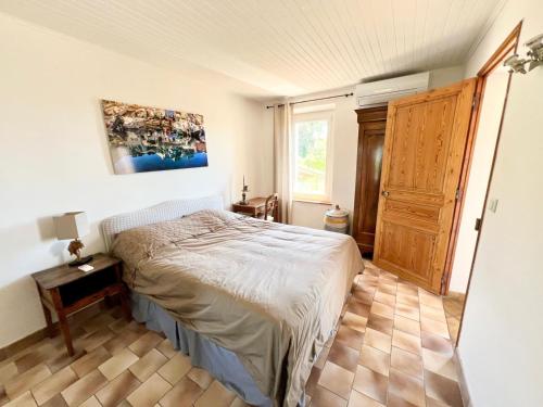 une chambre avec un lit et un parquet dans l'établissement Mas provençal vue mer à 5 min de la plage, à Sanary-sur-Mer