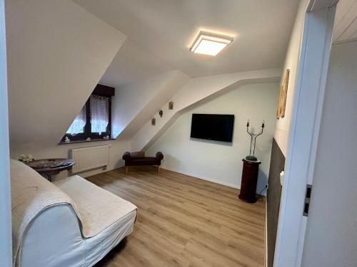 a attic room with a bed and a tv at La mansardina in Lörrach