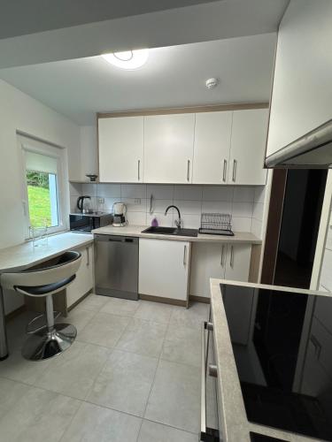 a kitchen with white cabinets and a sink and a counter at Cozy apartment in Tennfjord in Tennfjord