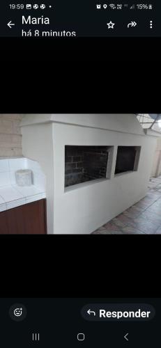 a picture of a white kitchen with a fireplace at Ap confortável in Tramandaí