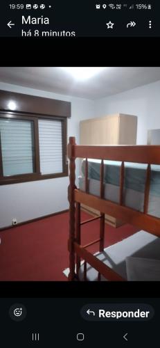 a picture of a bedroom with a wooden bench at Ap confortável in Tramandaí
