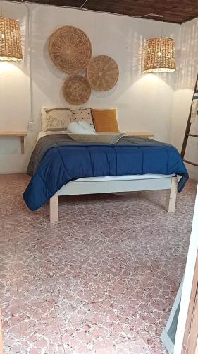 a bed with a blue blanket and a laptop on it at Hotel Neutro in San Cristóbal de Las Casas