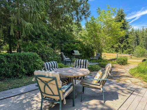 a wooden table and chairs on a patio at Dragonfly Haven in Sequim