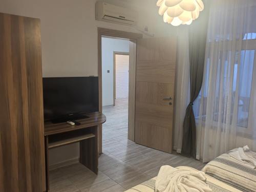a bedroom with a flat screen tv next to a door at ZORA guest APRTMENT in Vidin