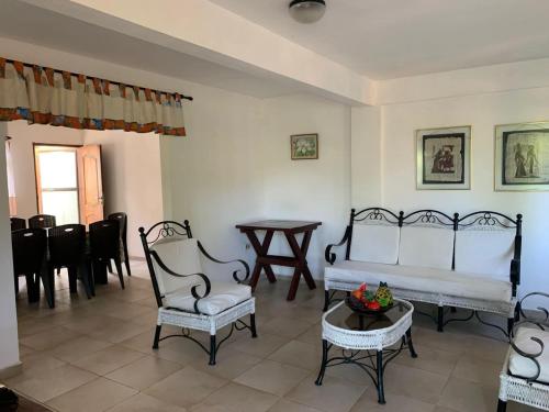 ein Wohnzimmer mit Stühlen, einer Couch und einem Tisch in der Unterkunft Casa de campo en Buena Vista - A una cuadra de la plaza in Buena Vista