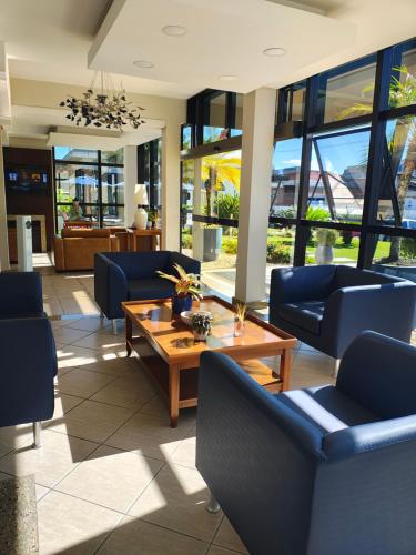 a living room with couches and a table and chairs at Hotel Itajara in Jaraguá do Sul