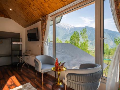 a room with a large window with a view of mountains at Moustache Hostel Pahalgam in Pahalgām