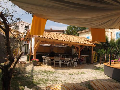 a patio with a table and chairs under a pavilion at Relax Apartments Grazia in Funtana