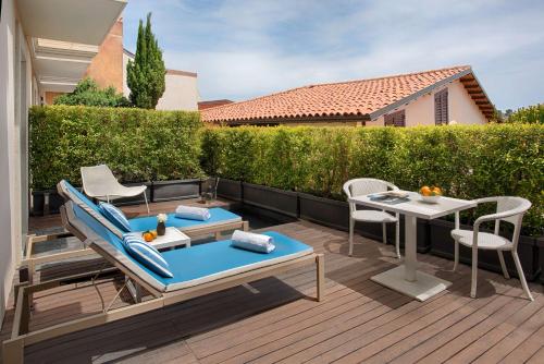 a patio with a table and chairs on a deck at NH Collection Taormina in Taormina