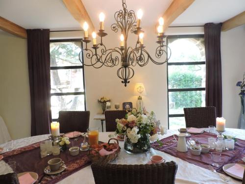 a dining room with a table and a chandelier at La Flor Azul in Grospierres
