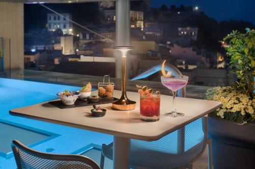 a table with food and drinks on a balcony at NH Collection Taormina in Taormina