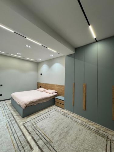 una camera da letto con un letto, armadi e un tappeto di SweetHome a Dushanbe