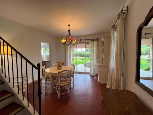 une salle à manger avec une table, des chaises et un lustre dans l'établissement Le Mas Rose, à Opio