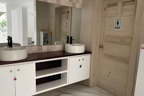 a bathroom with two sinks and a large mirror at Sweet Home Bayahibe in Bayahibe