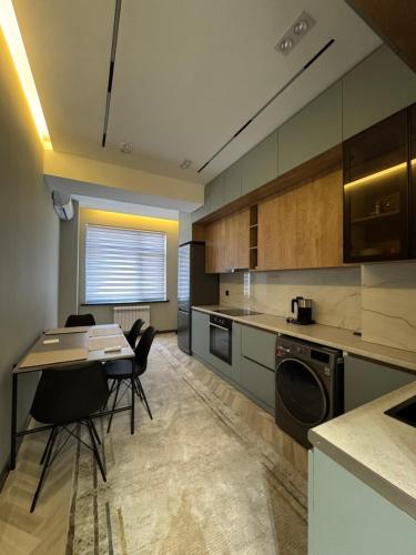 una cucina con un tavolo e sedie in una stanza di SweetHome a Dushanbe