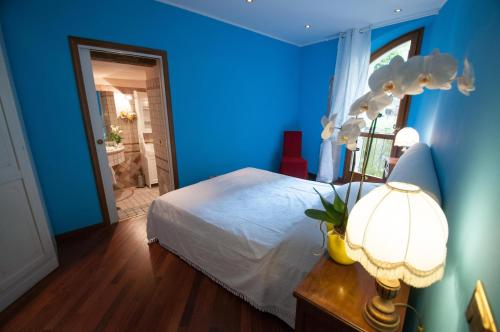 ヴィットリオ・ヴェネトにあるResidenza Venezia Cortinaの青いベッドルーム(ベッド1台、ランプ付きテーブル付)