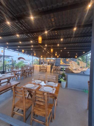 a restaurant with wooden tables and chairs and a boat at Villa Mossa Ambalangoda Boutique villa in Ambalangoda