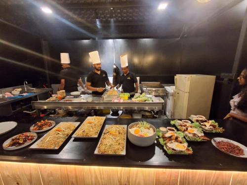 a group of chefs standing in a kitchen preparing food at Villa Mossa Ambalangoda Boutique villa in Ambalangoda