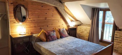 - une chambre avec un lit et un mur en bois dans l'établissement Le Grand Clos, à La Chapelle-Aubareil