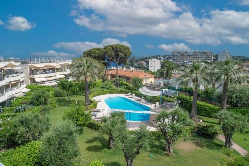 une vue aérienne d'un complexe avec piscine et palmiers dans l'établissement Jardin du soleil, à Roquebrune-Cap-Martin