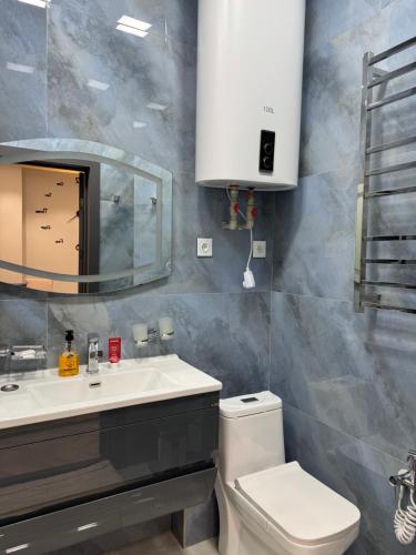 un bagno con lavandino, WC e specchio di SweetHome a Dushanbe