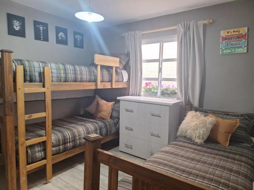 a room with two bunk beds and a couch at Alojamiento en Maipú in Maipú